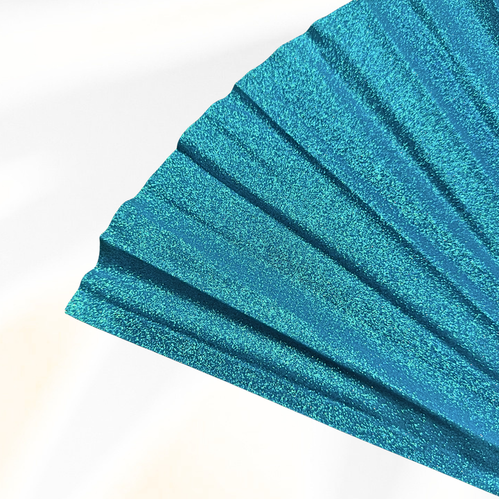 A close-up of a glittery teal blue pleated fan or fabric panel, shown against a clean white background.